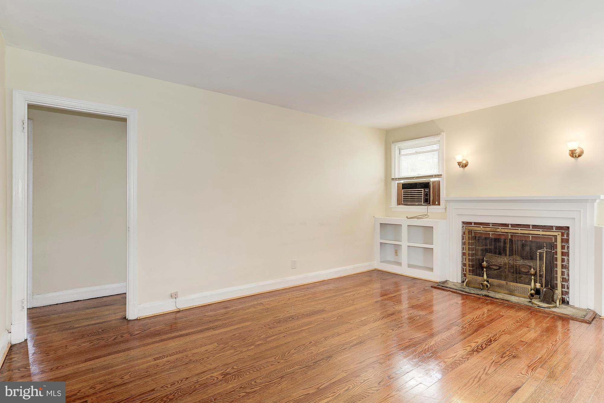 7925 Liberty Road Baltimore, MD 21244 - Photo 4 of 30 an empty room with wooden floor fireplace and window