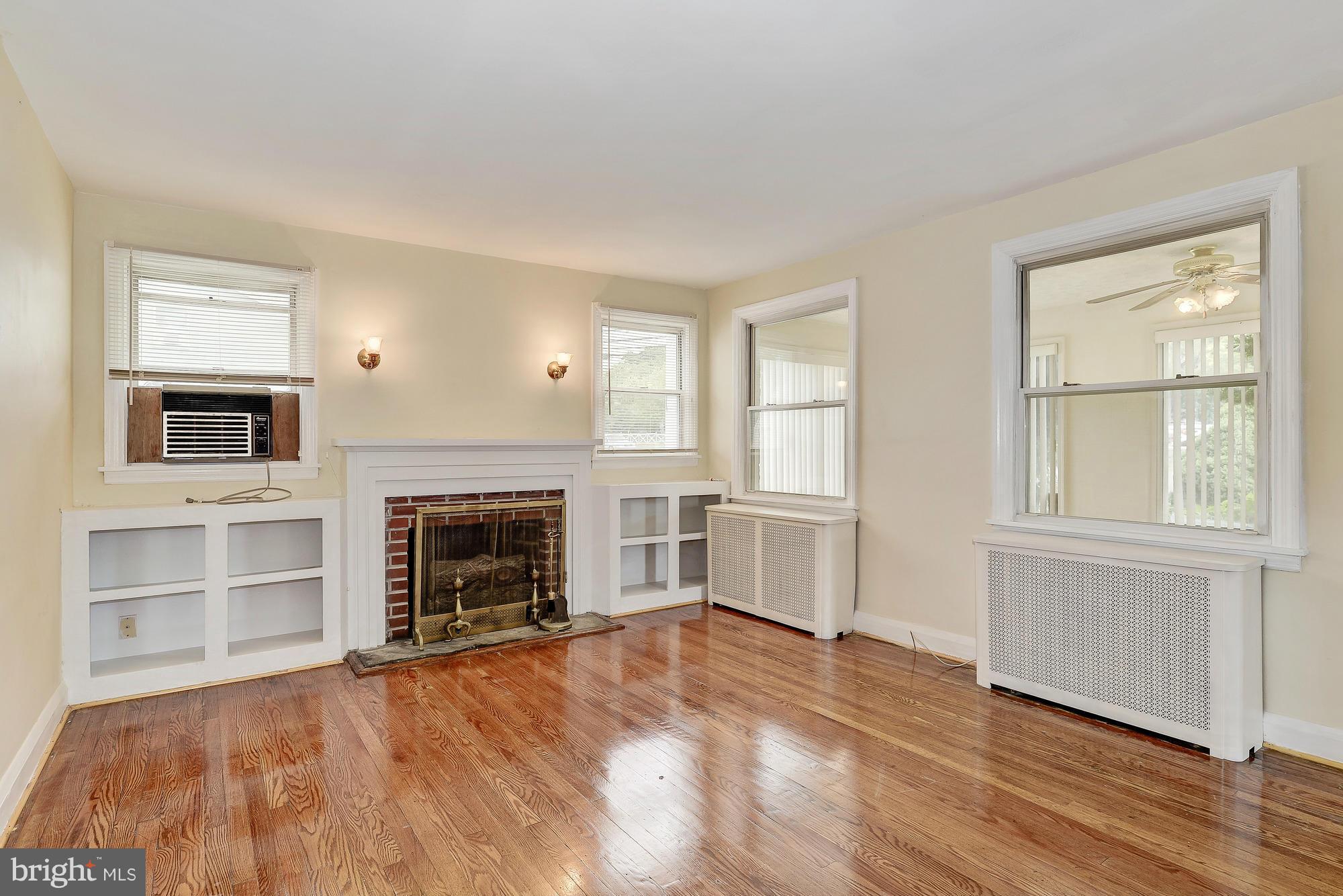 7925 Liberty Road Baltimore, MD 21244 - Photo 5 of 30 an empty room with fireplace cabinet and windows