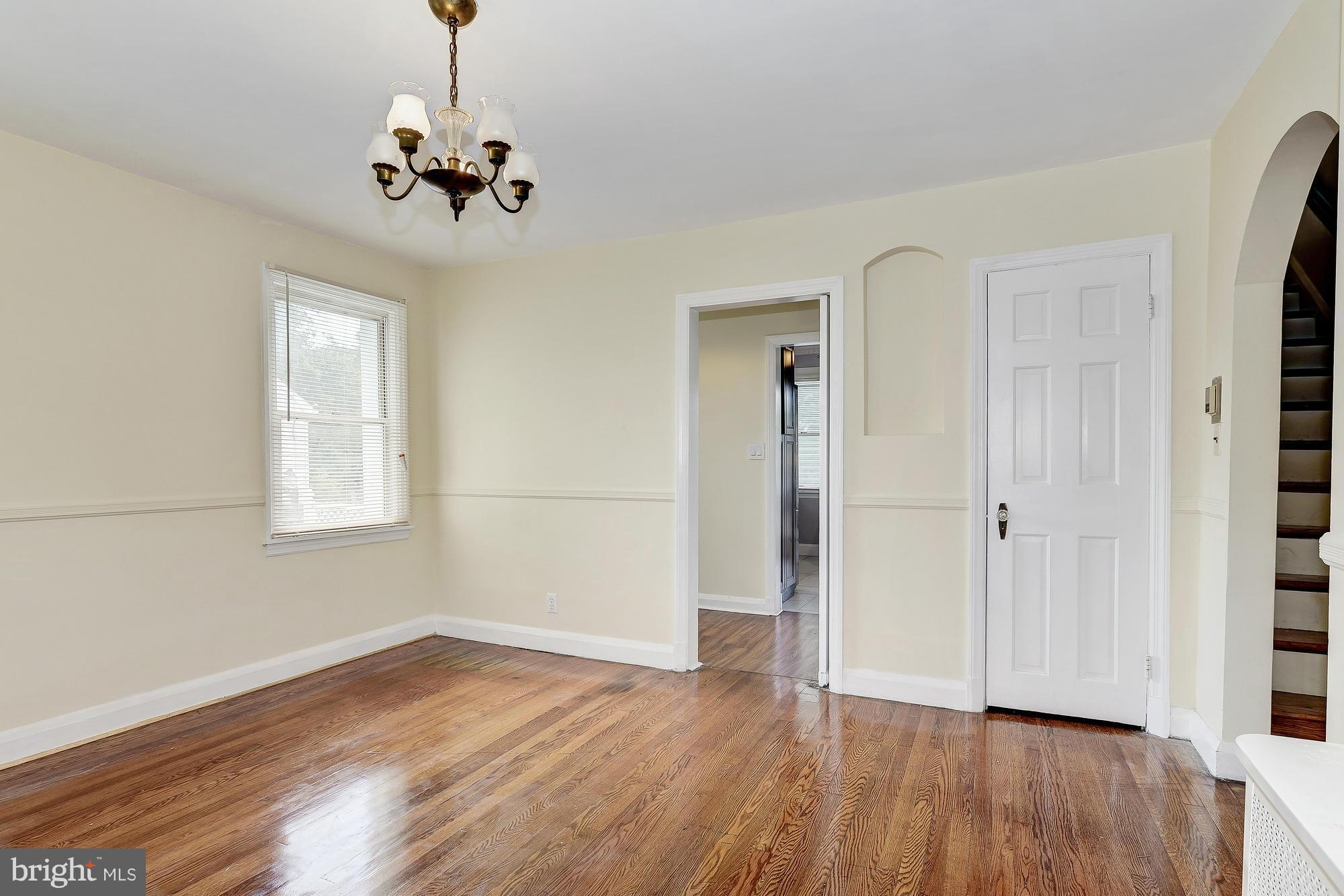 7925 Liberty Road Baltimore, MD 21244 - Photo 9 of 30 an empty room with wooden floor chandelier and windows