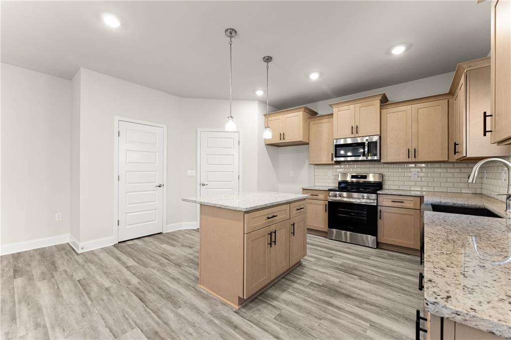 662 Forest Way Cornelia, GA 30531 - Photo 15 of 54 a kitchen with stainless steel appliances granite countertop a stove a sink and white cabinets with wooden floor