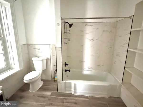 a bathroom with a toilet and a shower