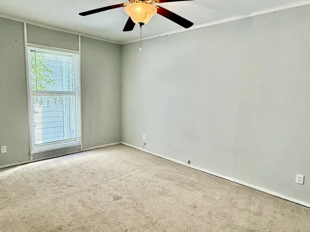 an empty room with closet and a ceiling fan