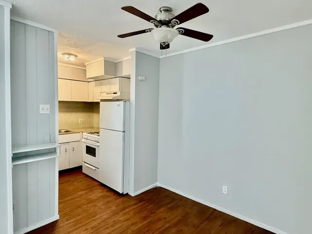a kitchen with granite countertop a sink a stove and cabinets