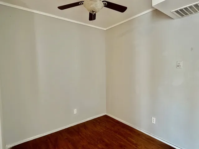 a view of a kitchen with a refrigerator and wooden floor