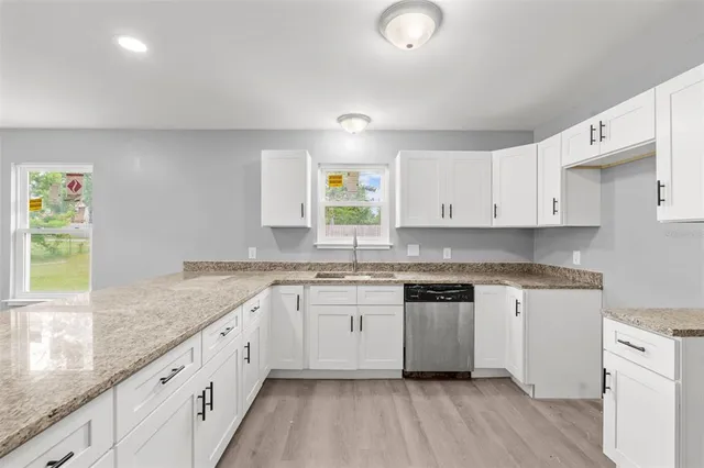 a spacious bathroom with a granite countertop sink and a mirror