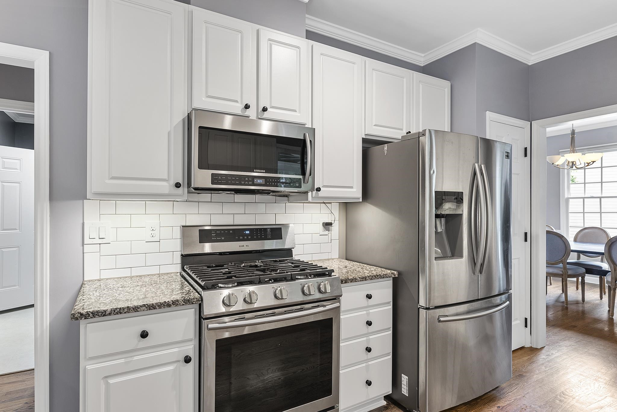 15 Otters Run Durham, NC 27712 - Photo 11 of 46 a kitchen with stainless steel appliances white cabinets a stove a microwave and a refrigerator