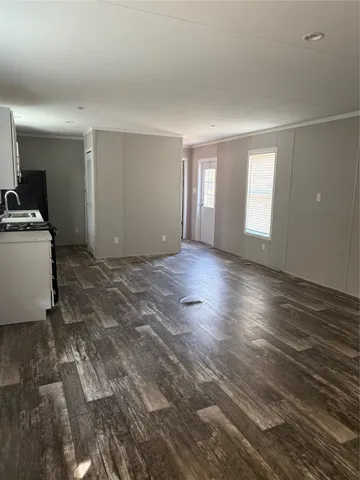 a kitchen with granite countertop a stove a sink and a white cabinets