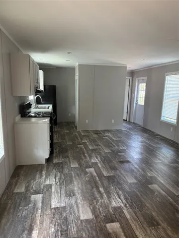 a kitchen with granite countertop white cabinets and black appliances
