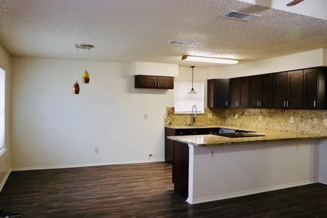 a kitchen with stainless steel appliances wooden floor and a counter top space