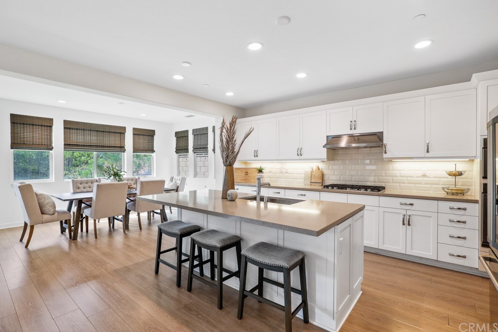 279 Barnes Road Tustin, CA 92782 - Photo 10 of 32 a kitchen with stainless steel appliances granite countertop a stove top oven a sink a dining table and chairs