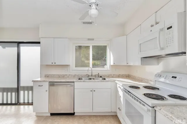 a bathroom with a granite countertop sink toilet and a mirror