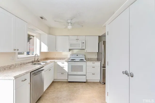 a view of a dining room with a table and chairs