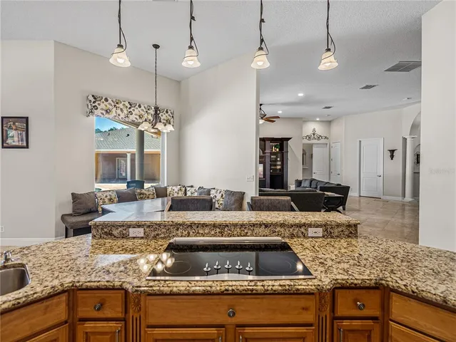 a spacious bathroom with a granite countertop sink a toilet a mirror and shower