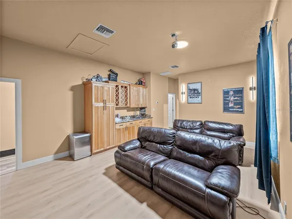 a living room with furniture a flat screen tv and kitchen view
