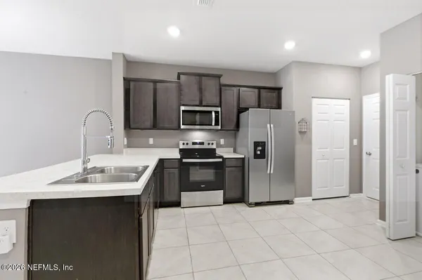 a kitchen with stainless steel appliances granite countertop a refrigerator a sink a stove a microwave and island