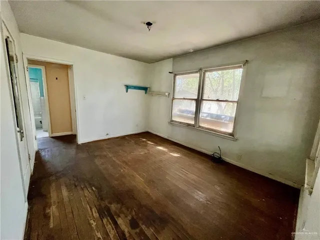 a view of a room that has a window and wooden floor