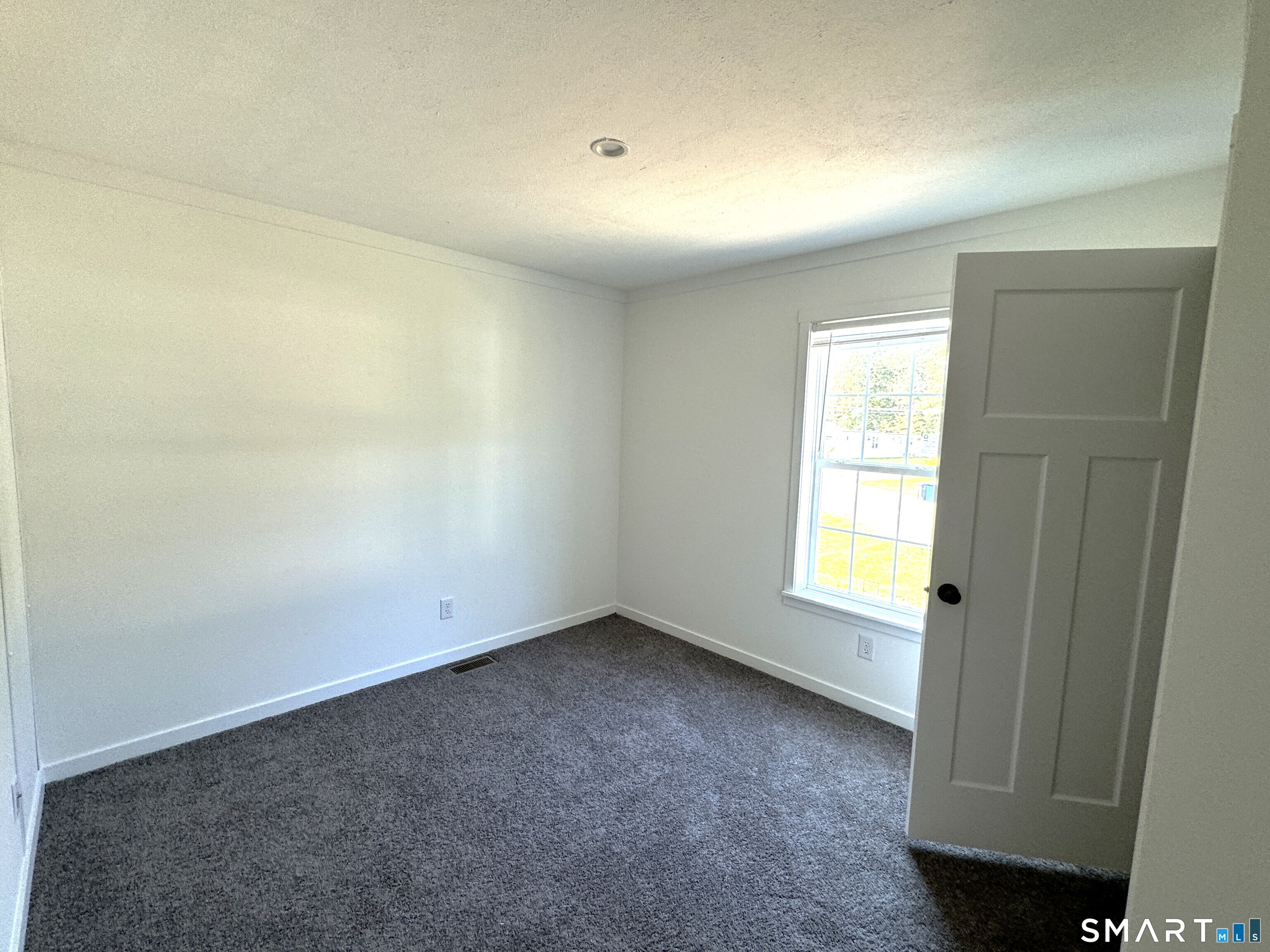 301 South Main Street Newtown, CT 06470 - Photo 6 of 17 an empty room with a window and a kitchen view