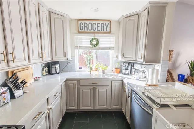 a kitchen with stainless steel appliances granite countertop a sink and a white cabinets