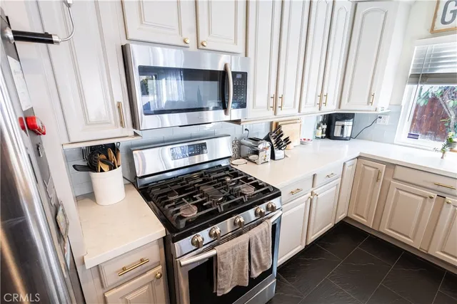 a kitchen with white cabinets and appliances