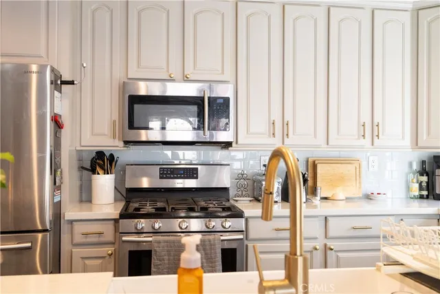 a kitchen with stainless steel appliances granite countertop a stove and a refrigerator