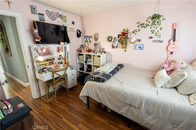 a bedroom with a bed and flat tv screen on the dresser