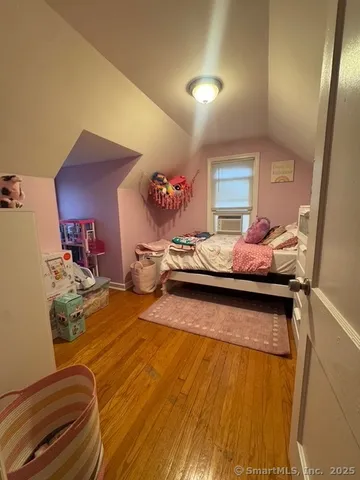 a bedroom with a bed and a potted plant on dresser