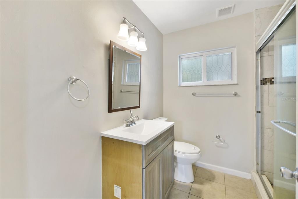 2331 West Oak Street Kissimmee, FL 34741 - Photo 15 of 34 a bathroom with a toilet sink and mirror