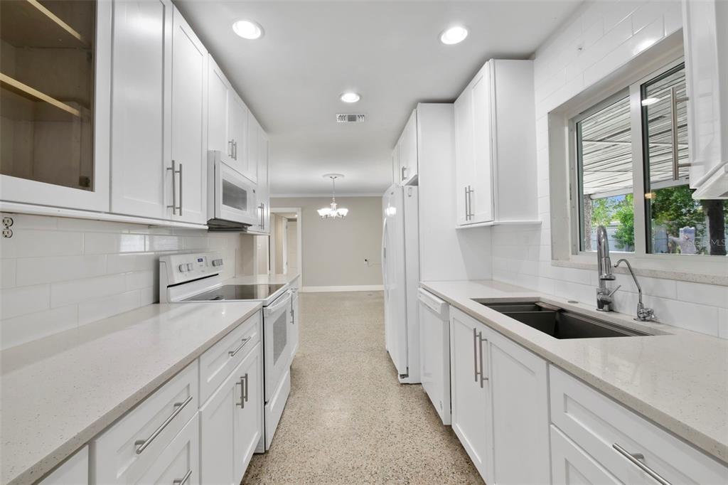 2331 West Oak Street Kissimmee, FL 34741 - Photo 5 of 34 a kitchen with granite countertop a sink and white cabinets