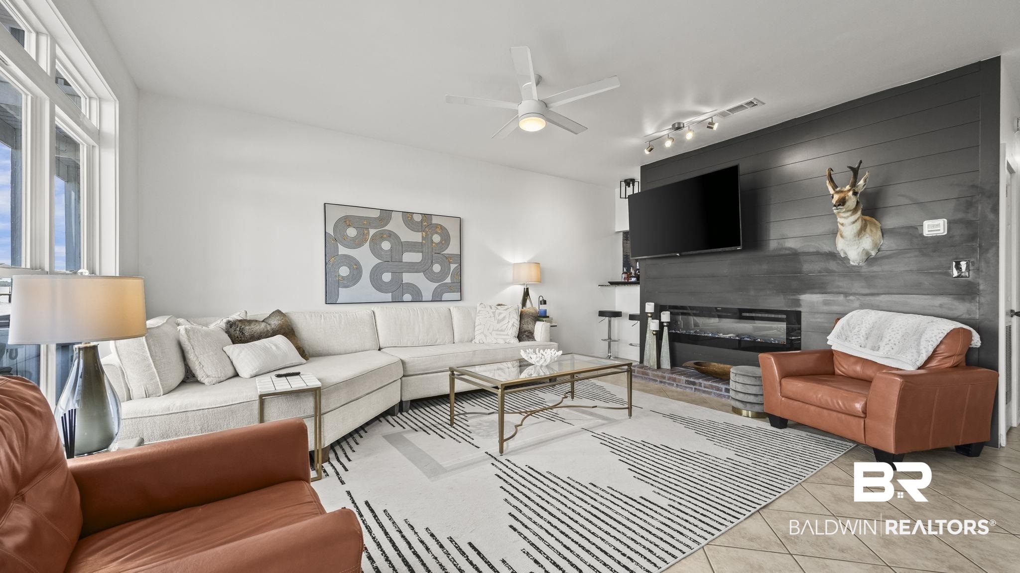 26063 Canal Road, Unit 2F Orange Beach, AL 36561 - Photo 13 of 36 Living room featuring tile patterned floors, a ceiling fan, and wooden walls