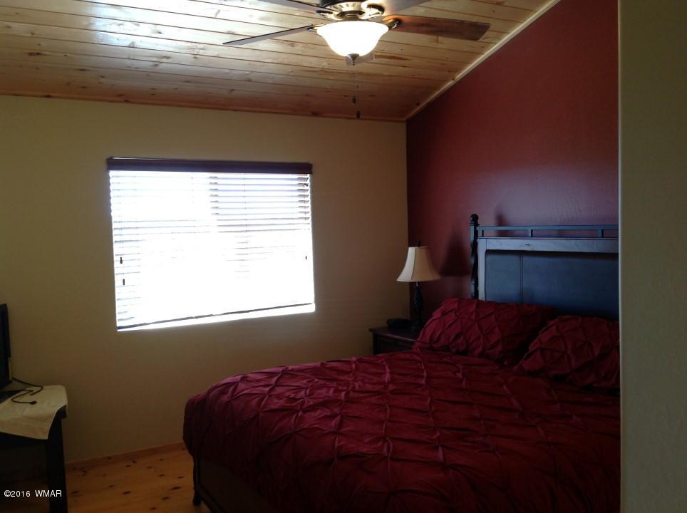 2972 Lodgepole Road Overgaard, AZ 85933 - Photo 15 of 41 a bedroom with a bed and window
