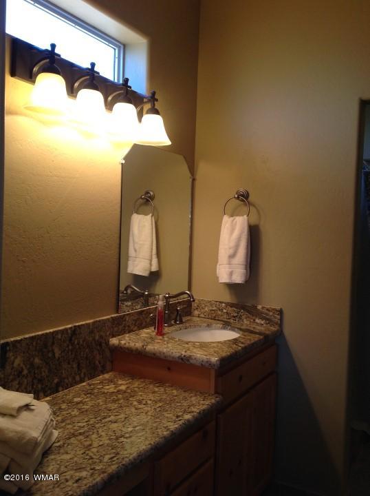 2972 Lodgepole Road Overgaard, AZ 85933 - Photo 18 of 41 a bathroom with a granite countertop sink and a mirror
