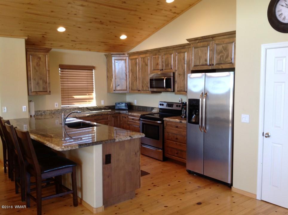 2972 Lodgepole Road Overgaard, AZ 85933 - Photo 2 of 41 a kitchen with kitchen island a counter space a sink appliances and cabinets