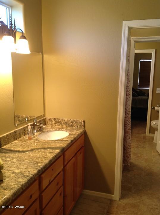 2972 Lodgepole Road Overgaard, AZ 85933 - Photo 21 of 41 a bathroom with a granite countertop sink and a mirror
