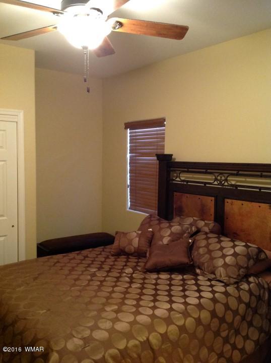 2972 Lodgepole Road Overgaard, AZ 85933 - Photo 22 of 41 a bedroom with a bed and a lamp