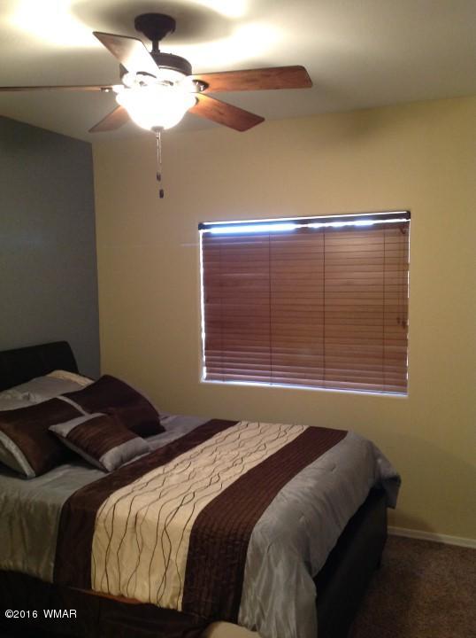 2972 Lodgepole Road Overgaard, AZ 85933 - Photo 32 of 41 a bedroom with a bed and a chandelier