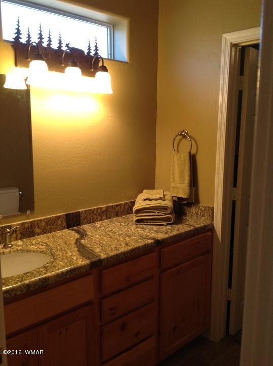 2972 Lodgepole Road Overgaard, AZ 85933 - Photo 35 of 41 a bathroom with a granite countertop sink and a mirror