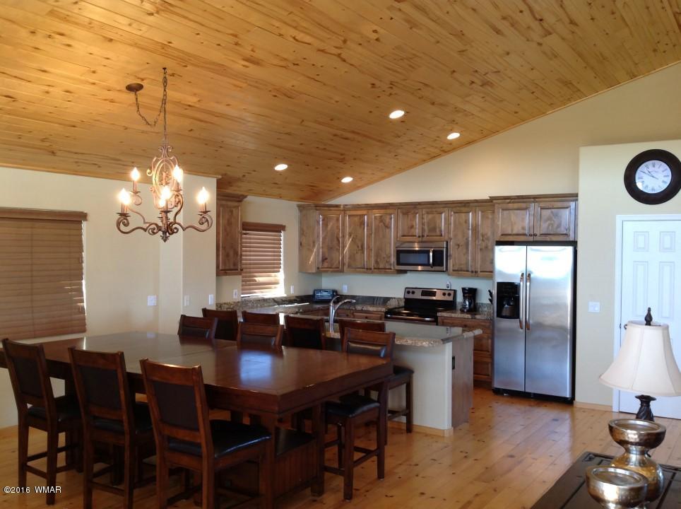 2972 Lodgepole Road Overgaard, AZ 85933 - Photo 5 of 41 a kitchen with stainless steel appliances granite countertop a sink dishwasher a stove a refrigerator with a dining table and chairs