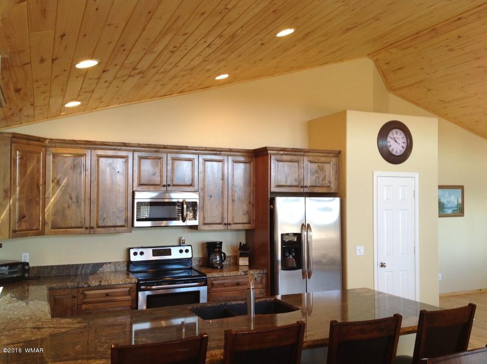 2972 Lodgepole Road Overgaard, AZ 85933 - Photo 9 of 41 a kitchen with stainless steel appliances granite countertop a refrigerator a stove and a microwave with wooden floor