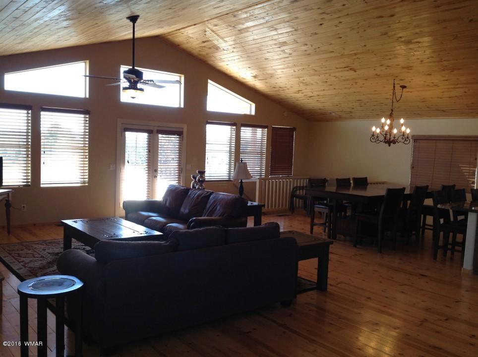 2972 Lodgepole Road Overgaard, AZ 85933 - Photo 10 of 41 a living room with furniture and a chandelier