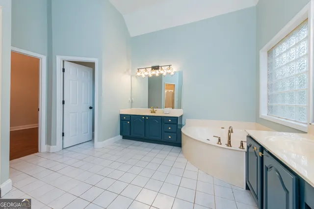 a spacious bathroom with a double vanity sink and a mirror