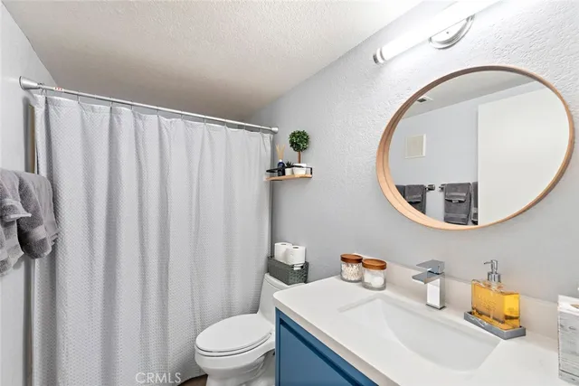 a bathroom with a sink mirror and toilet