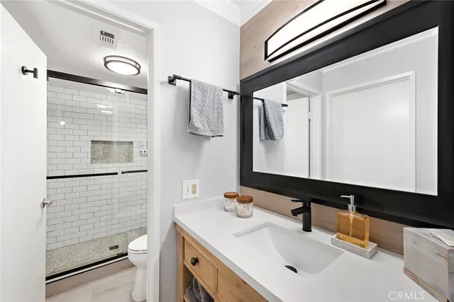 a bathroom with a sink a toilet and shower