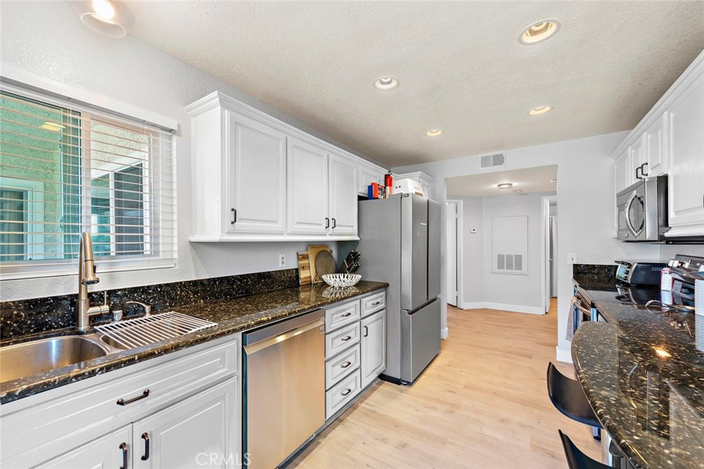 70 Corniche Drive, Unit A Dana Point, CA 92629 - Photo 27 of 27 a kitchen with granite countertop a sink a counter top space cabinets and stainless steel appliances