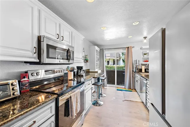 a kitchen with stainless steel appliances granite countertop a stove top oven a sink and dishwasher