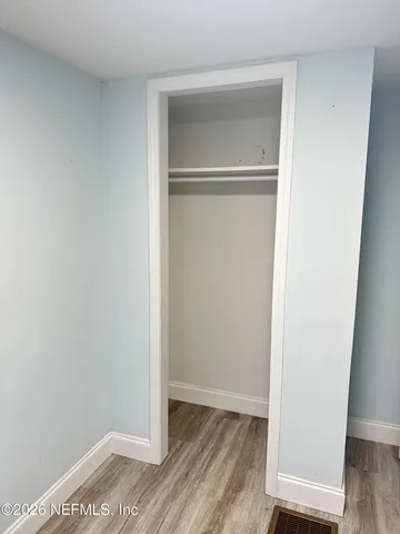 a view of walk in closet with wooden floor