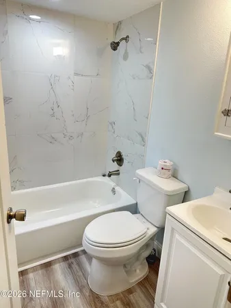 a white toilet and tub sitting next to a bathroom sink