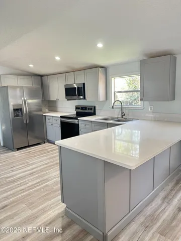 a large kitchen with kitchen island a sink stainless steel appliances and cabinets