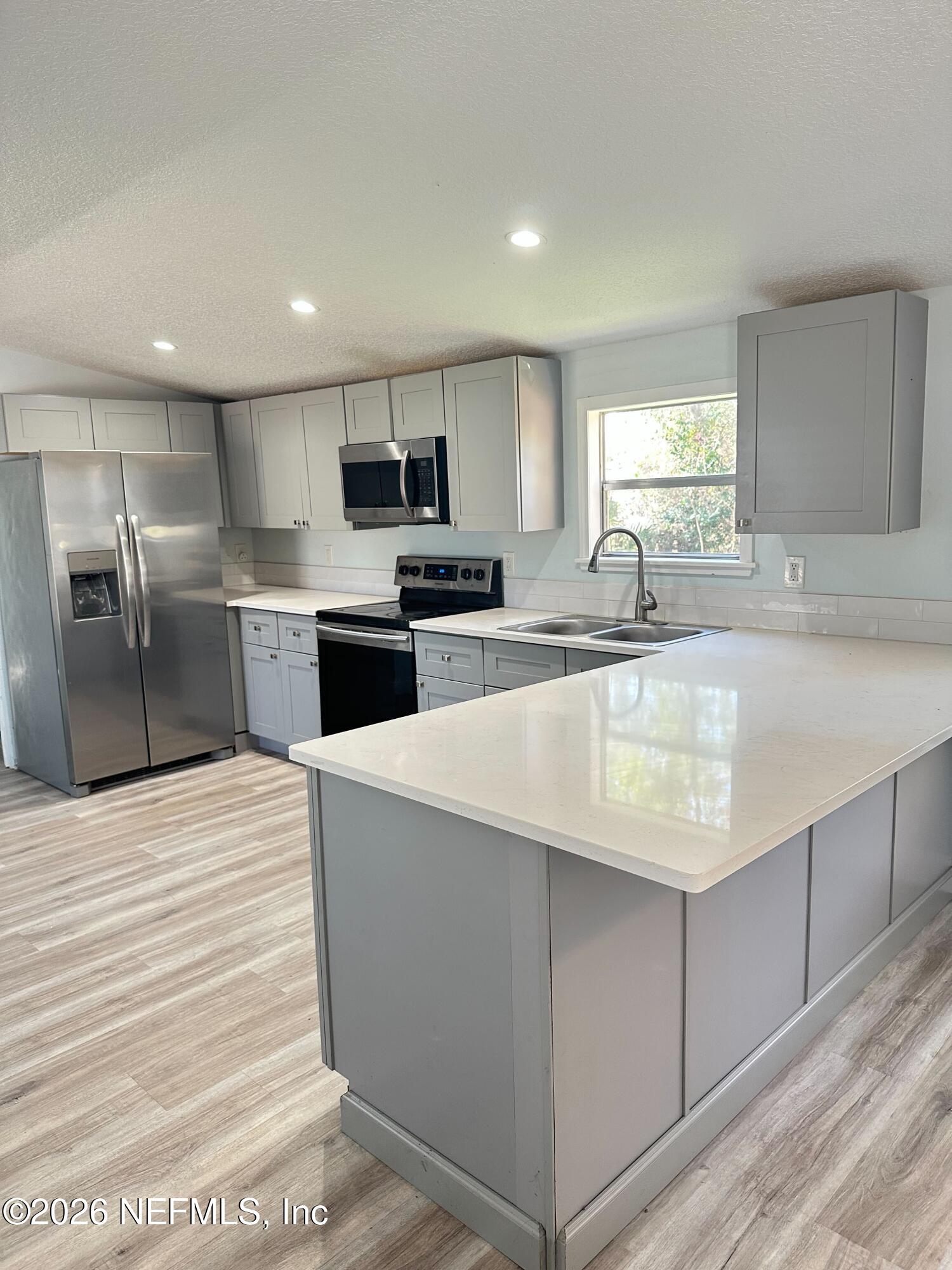 1635 Natalie Road St. Augustine, FL 32084 - Photo 2 of 16 a large kitchen with kitchen island a sink stainless steel appliances and cabinets