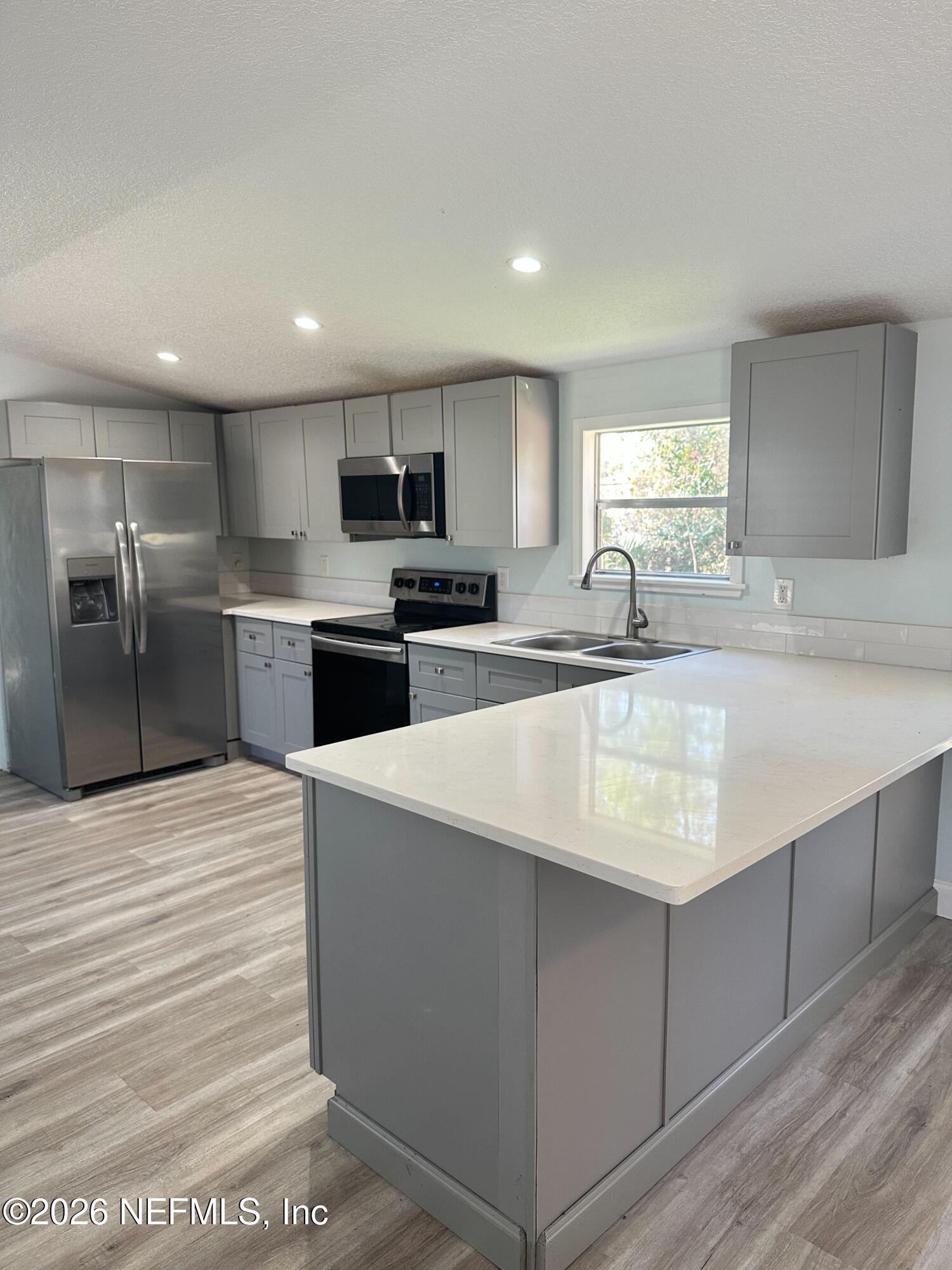 1635 Natalie Road St. Augustine, FL 32084 - Photo 4 of 16 a large kitchen with kitchen island a sink stainless steel appliances and cabinets