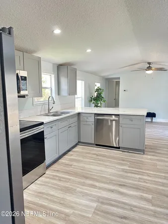 a large kitchen with stainless steel appliances granite countertop a sink and cabinets